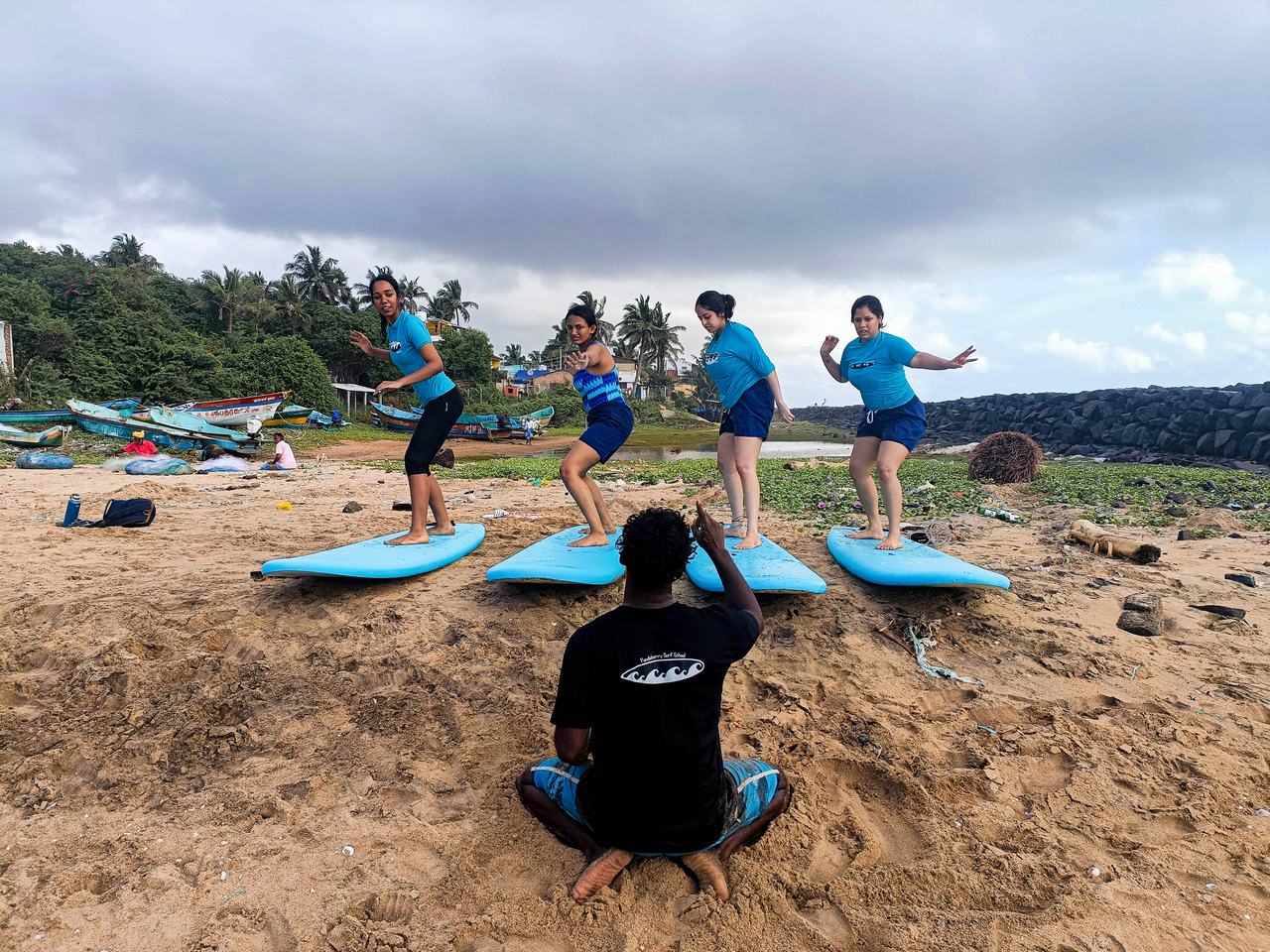 Students practising the pop-up on boards laid out on the sand